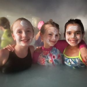 girls wearing face masks in a pool