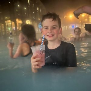 student having a drink in a pool