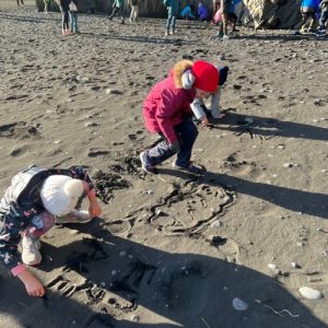 students writing on sand