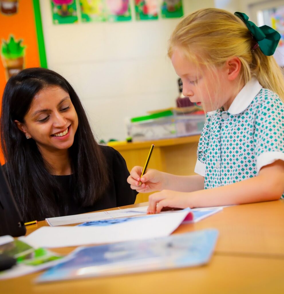 girl and a teacher working at their desk